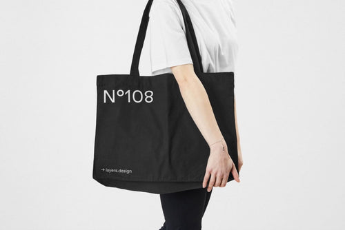 Minimal black canvas tote bag on neutral background