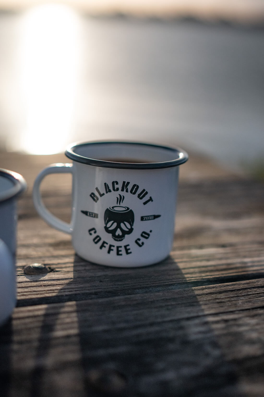Matte black enamel steel camping mug on dark surface