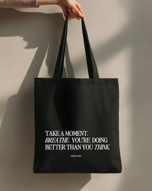 Minimal black canvas tote bag on neutral background