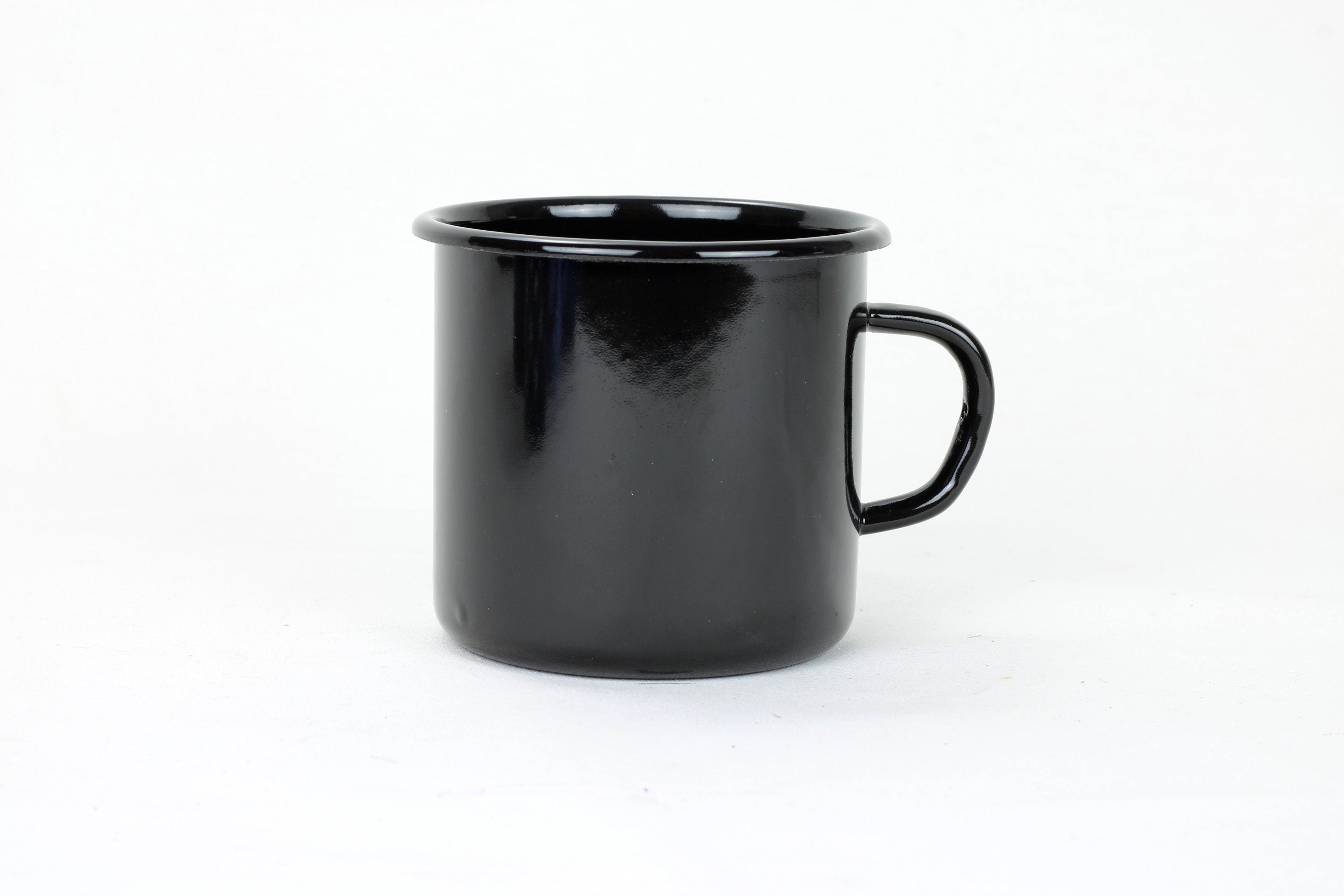 Matte black enamel steel camping mug on dark surface